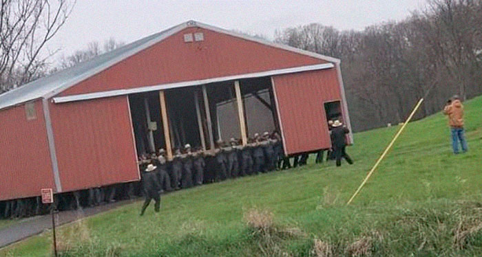 Members of the Amish community literally moving a barn by hand and sheer manpower.