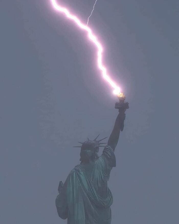 The Stature of Liberty's torch getting struck by lightning.