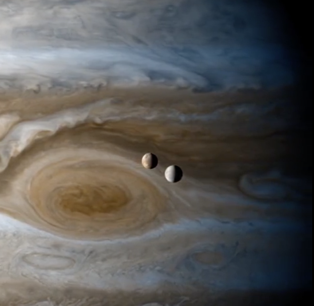 The moons Io and Europa passing by Jupiter, caught by Cassini.