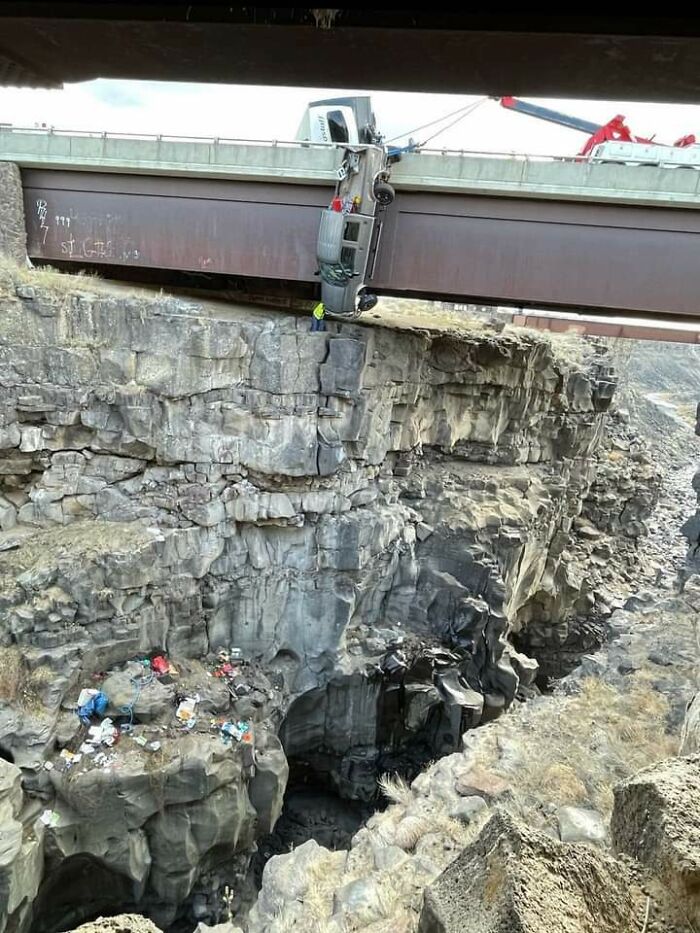 The people in this truck were extremely lucky that the safety chains on their truck and camper saved them from falling to certain death after crashing over the edge of a bridge.