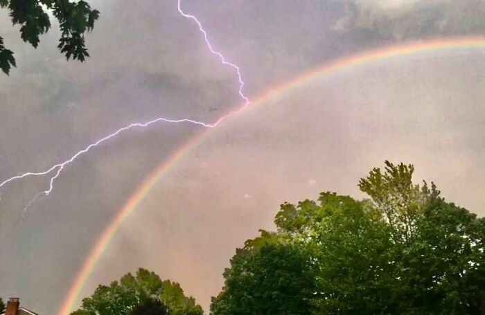 A rainbow appears to be 'deflecting' a bold of lightning in this one wild photo.