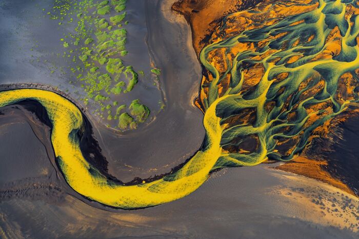 Colorful rivers that flow across the Icelandic terrain look like the veins of the Earth.