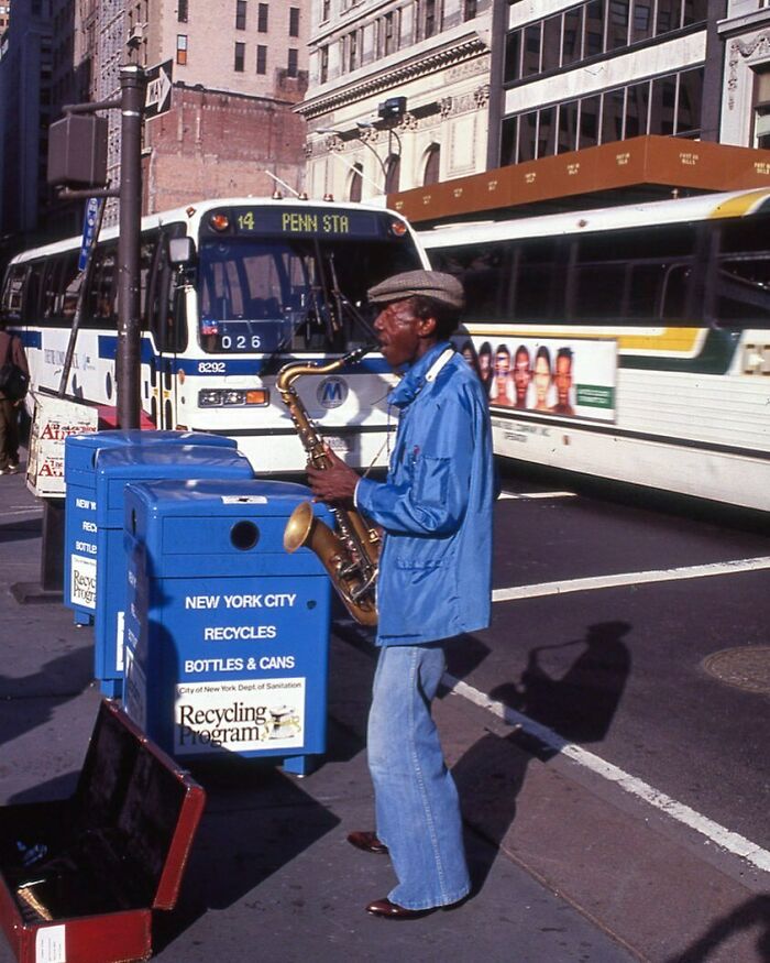 A man on the sidewalk of 5th Avenue in 1991 jams out on the saxophone.