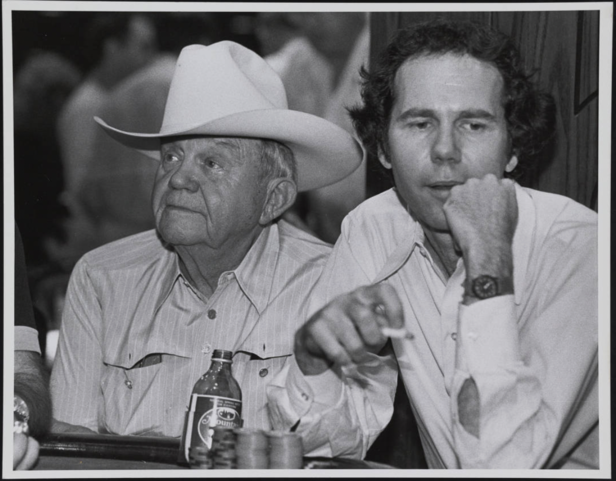 Gambler, gangster, and founder of the Horseshoe Casino, Benny Binion sits at a poker table with his son Ted Binion in Las Vegas, 1970s.