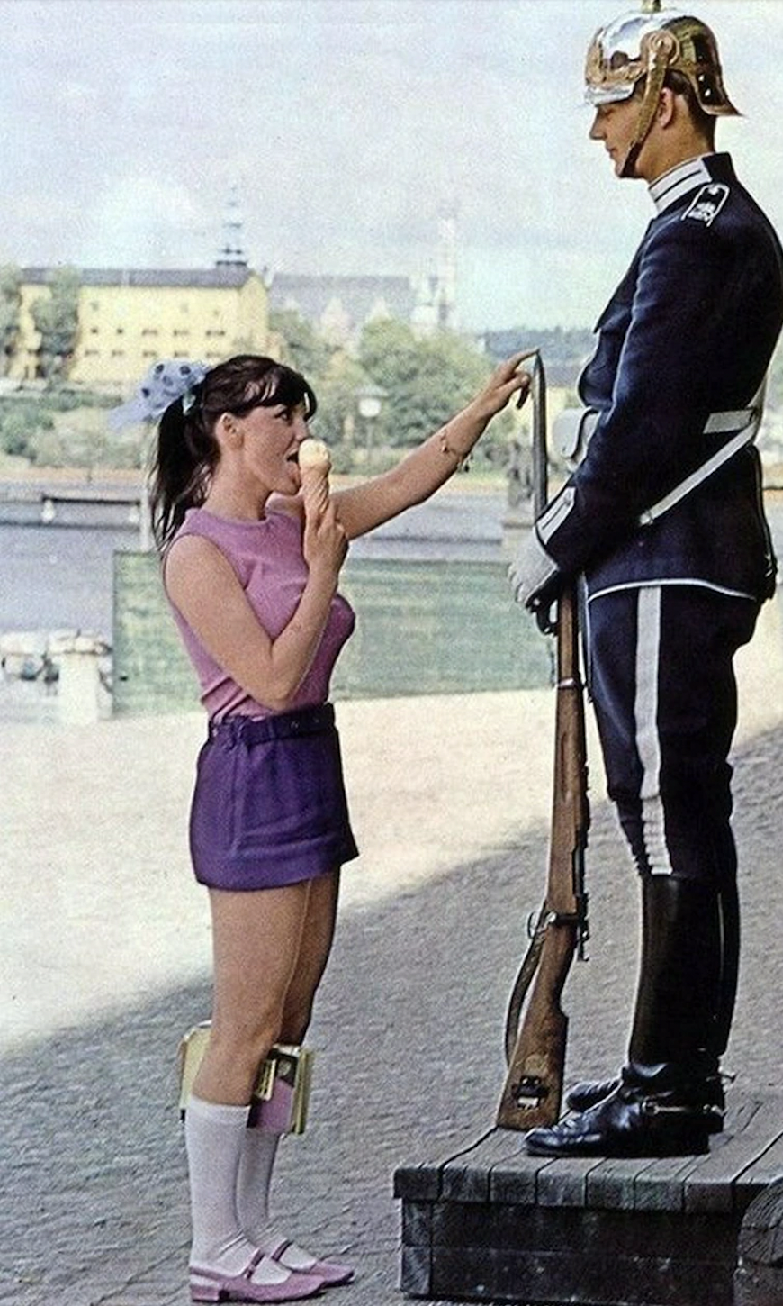 A girl licks ice cream to try and elicit a reaction from a royal guard in Sweden in 1970.