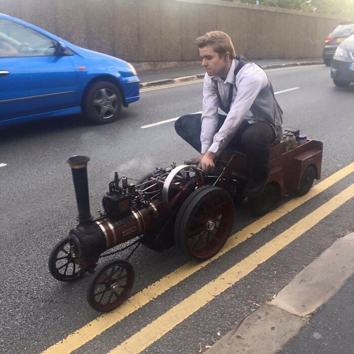 Just a dude cruising around town on a miniature steam-locomotive.