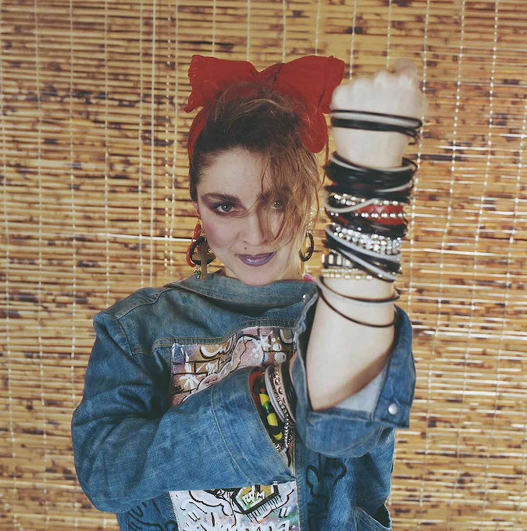 Madonna with a backwards jean jacket and more bracelets than we care to count right now.
