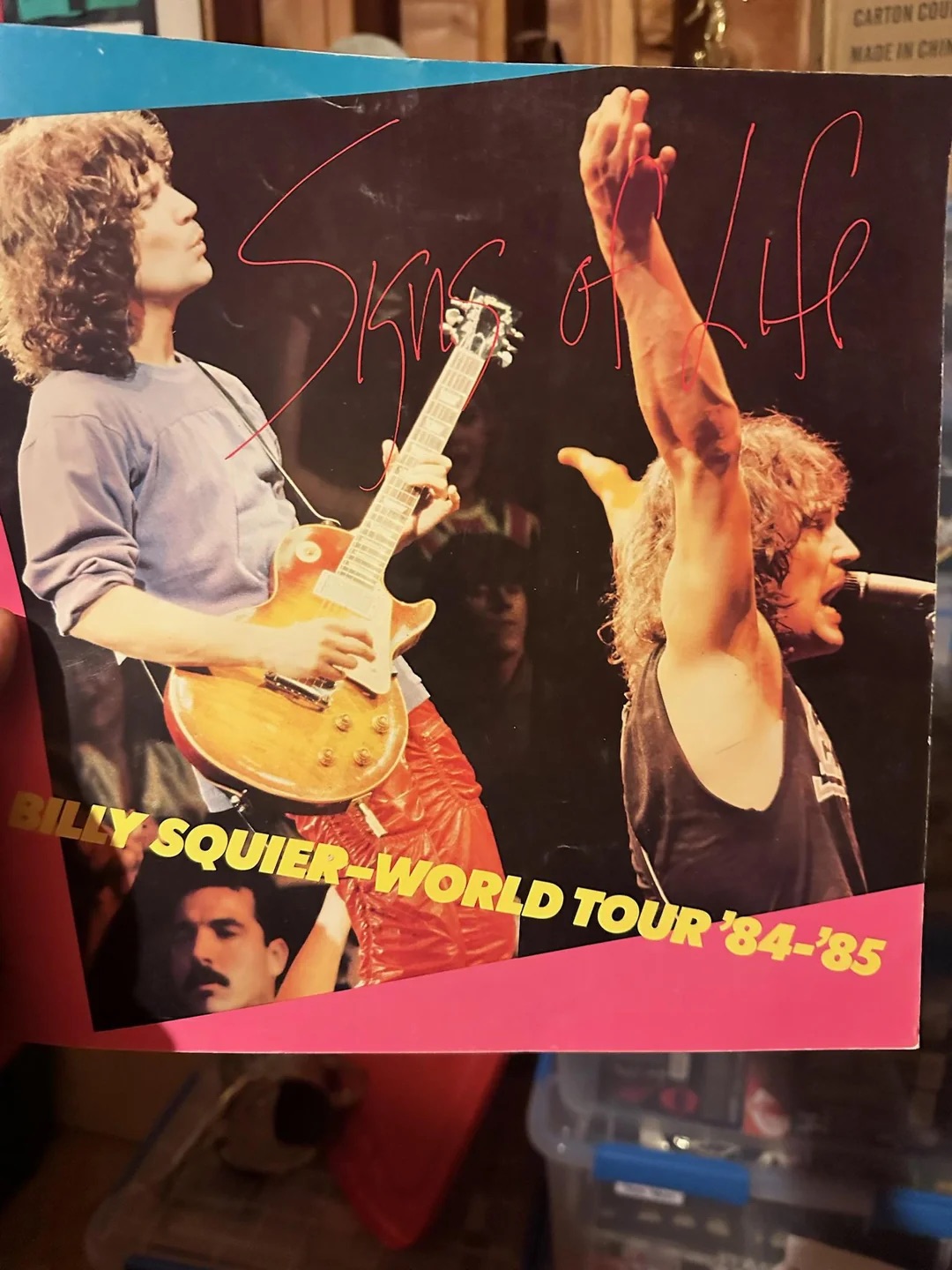 A fan holds a poster of Billy's "Signs of Life" Tour in 1984-85.
