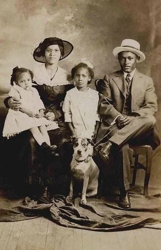 A family poses with their dog in 1910.