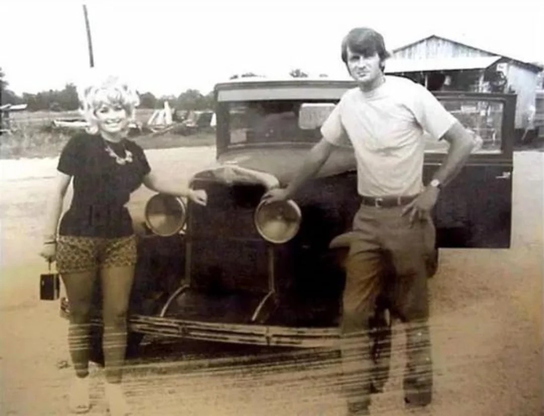 Dolly Parton and her husband Carl Dean with a vintage car in the 1960s.