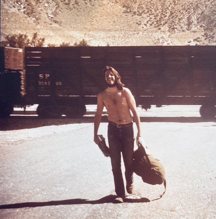 Shirtless Dude Hitchhiking West, Chasing the Dream (Or a Beach)