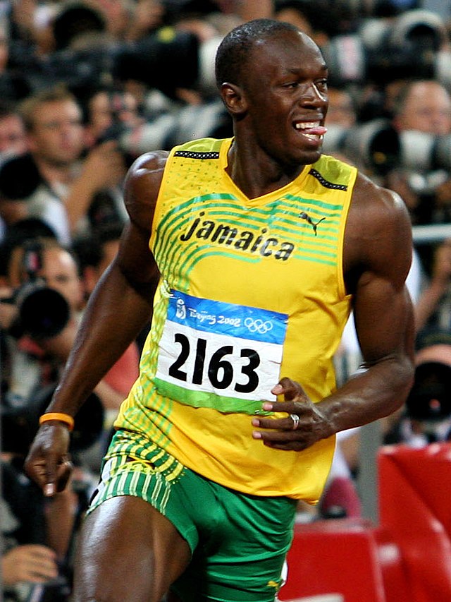 Usain Bolt smiling while winning in the 2008 Olympics.