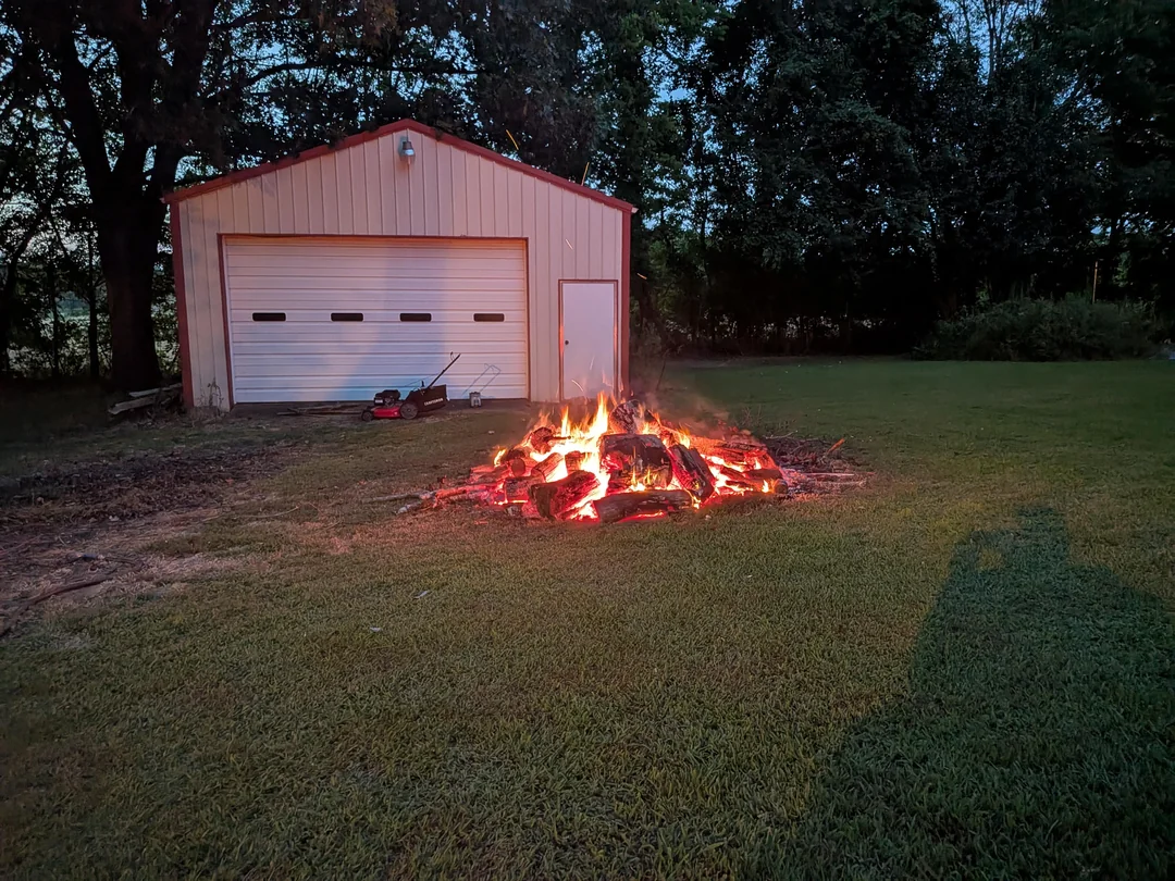 Flames crackle to the audience of damp grass.