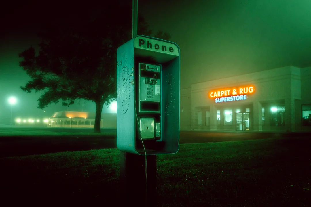 A payphone stuck in time, line long dead.
