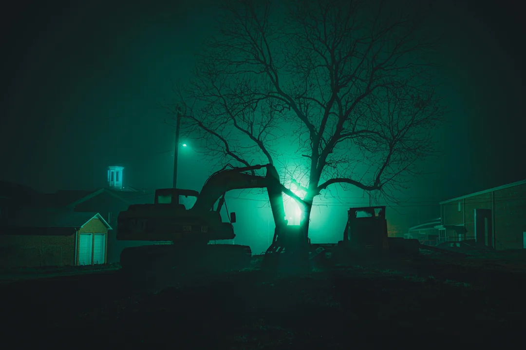 Ghostly street lamps shining between abandoned metals.