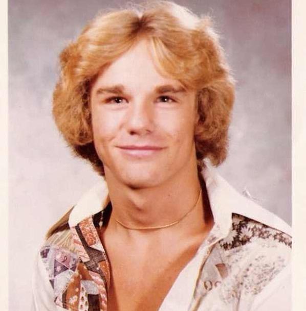 Yearbook smile, disco collar.