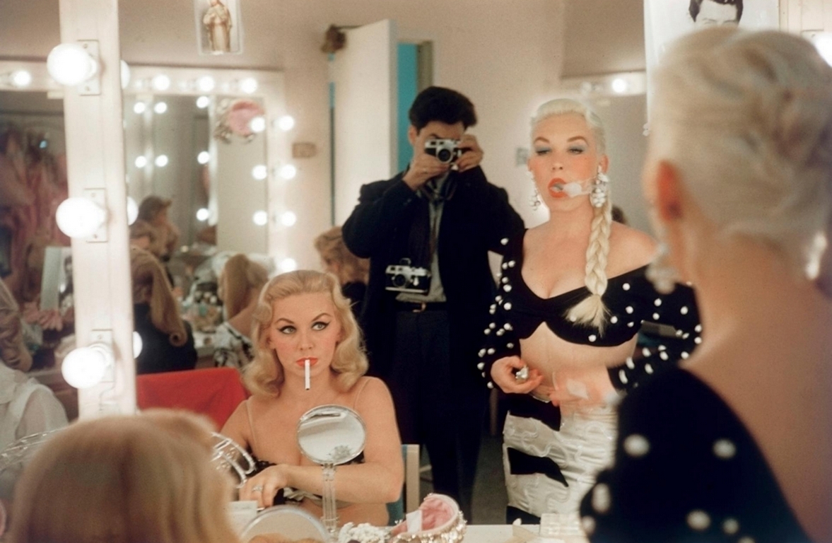 Backstage chaos: showgirls fixing lipstick, smoking, and stealing moments before the spotlight called.
