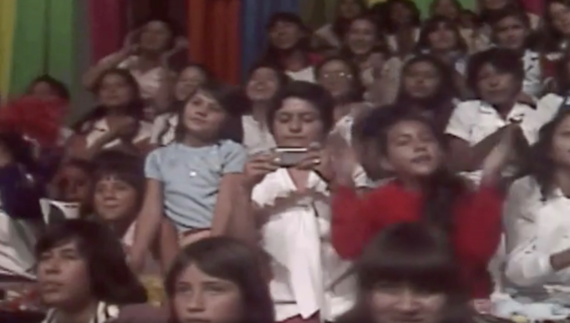 Audience Member in the ’80s Holding a Smartphone