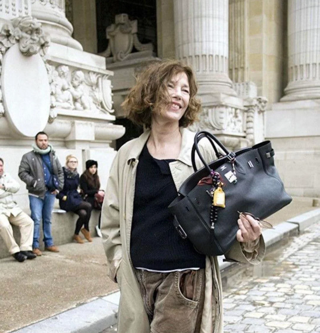 A bag without ceremony, scuffed, overstuffed, adorned with trinkets, making it truly hers.