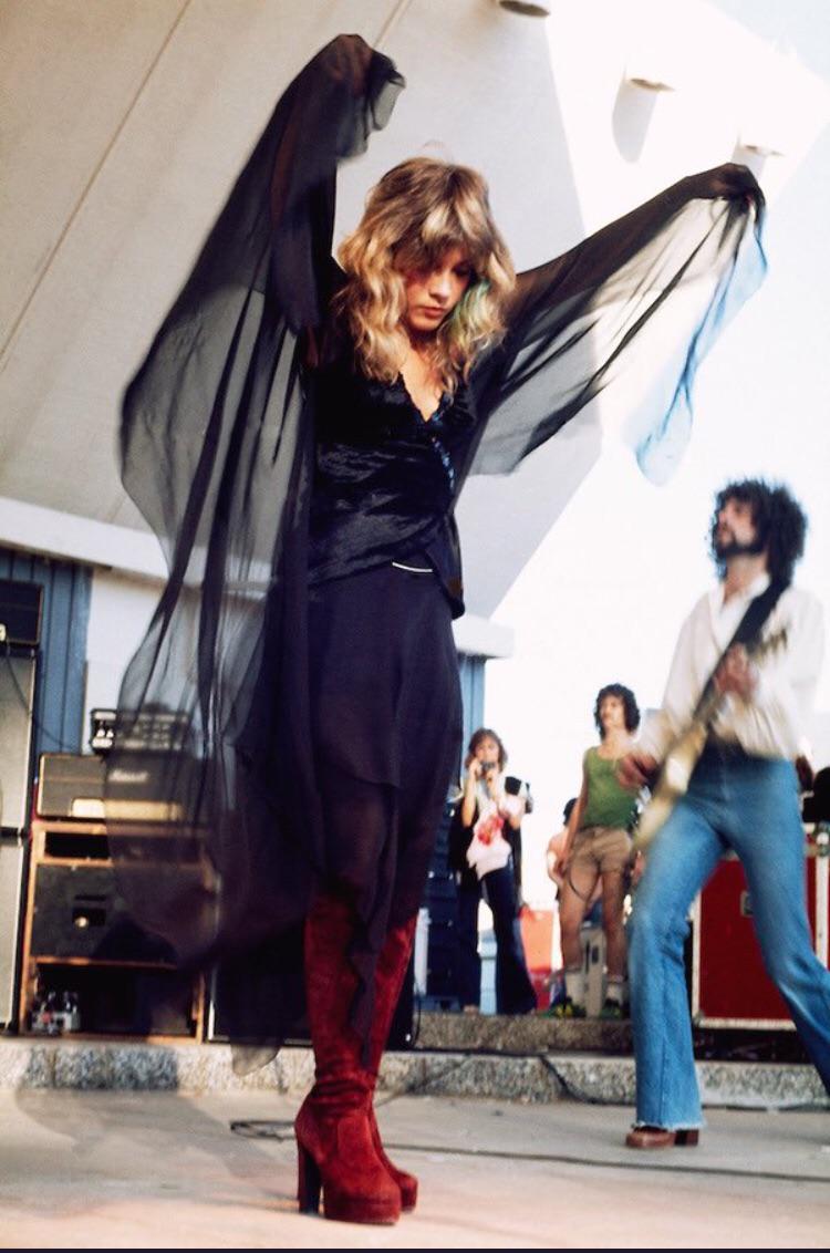 On stage in 1976, flowing black with red boots, the “Rhiannon” era in full bloom.