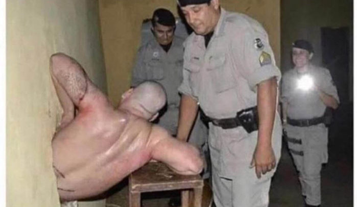 Guards surround a prisoner stuck halfway through a wall, his failed breakout captured on camera.
