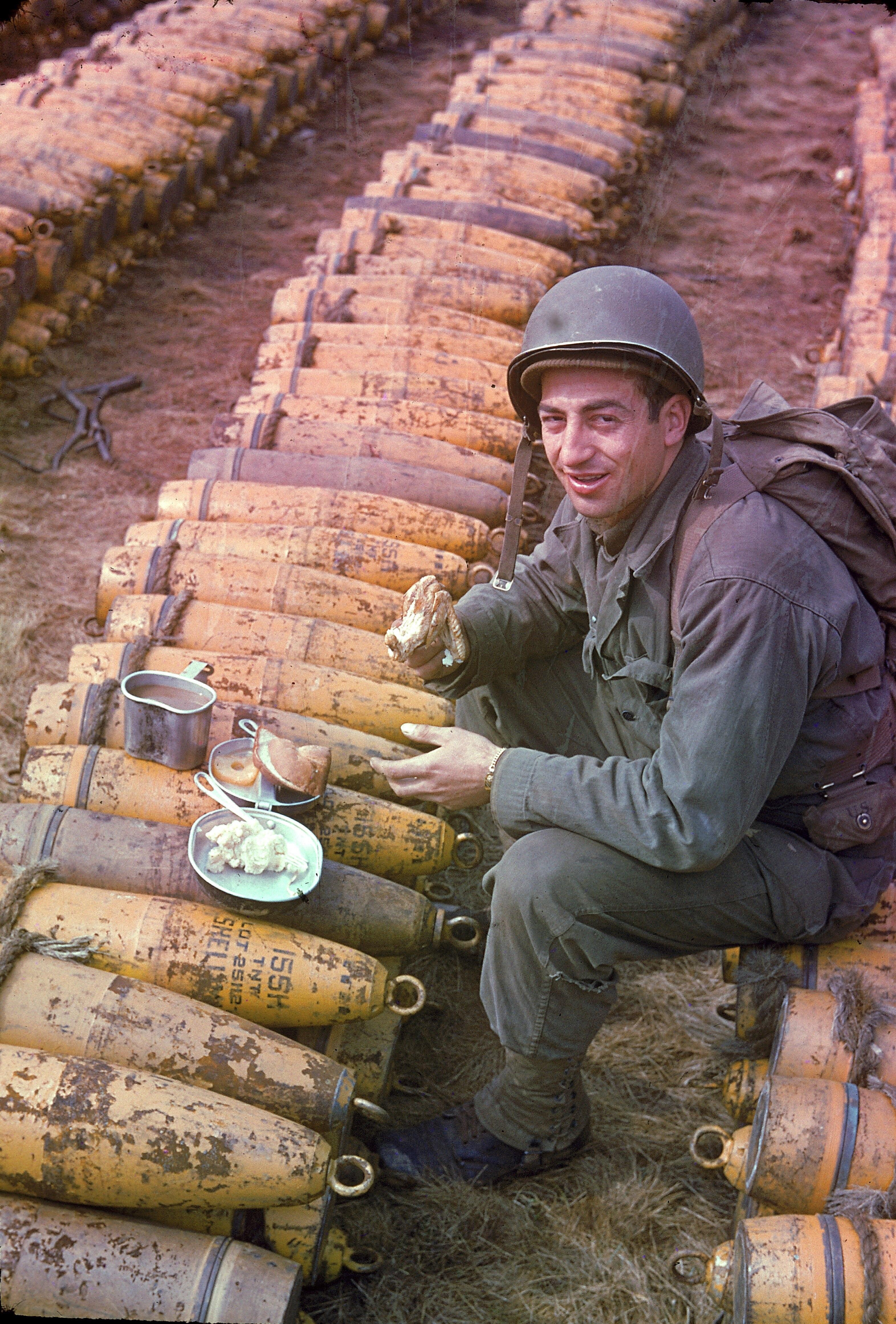 Eating his rations with a weary smile.