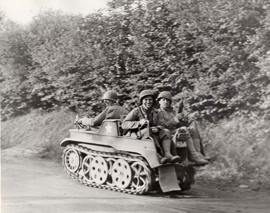 American soldiers ride a small vehicle through the rural roads.