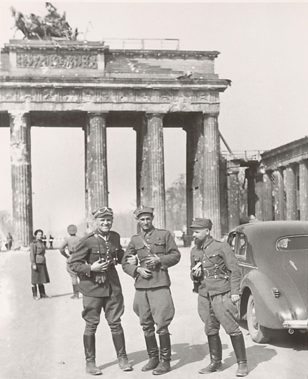 Celebrating victory in Berlin, before the war-damaged monument.