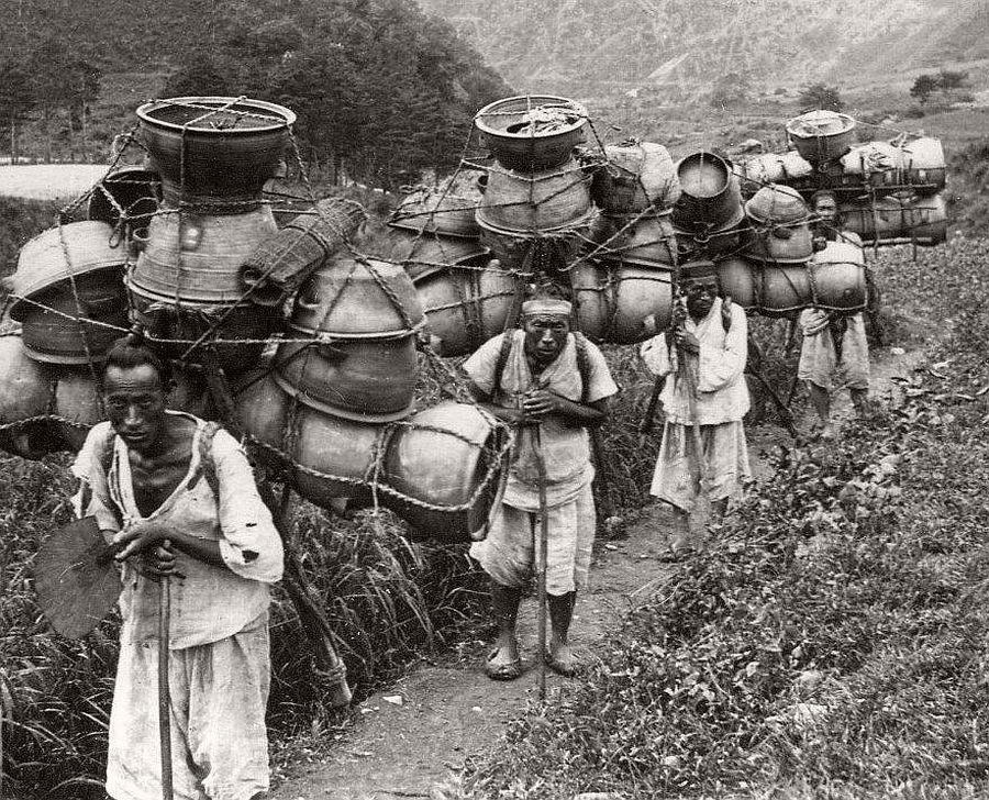 Korean porters carrying pots, 1900s