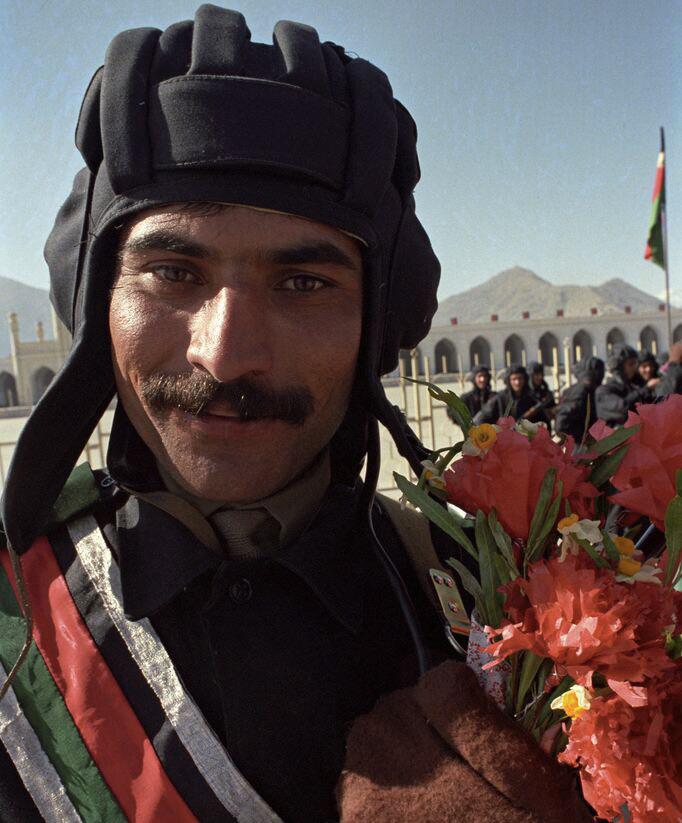 Between battles and borders, a smile and flowers still bloom.