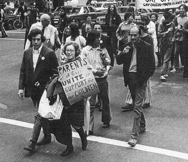 Parents proudly join a parade in the 1970s standing strong.
