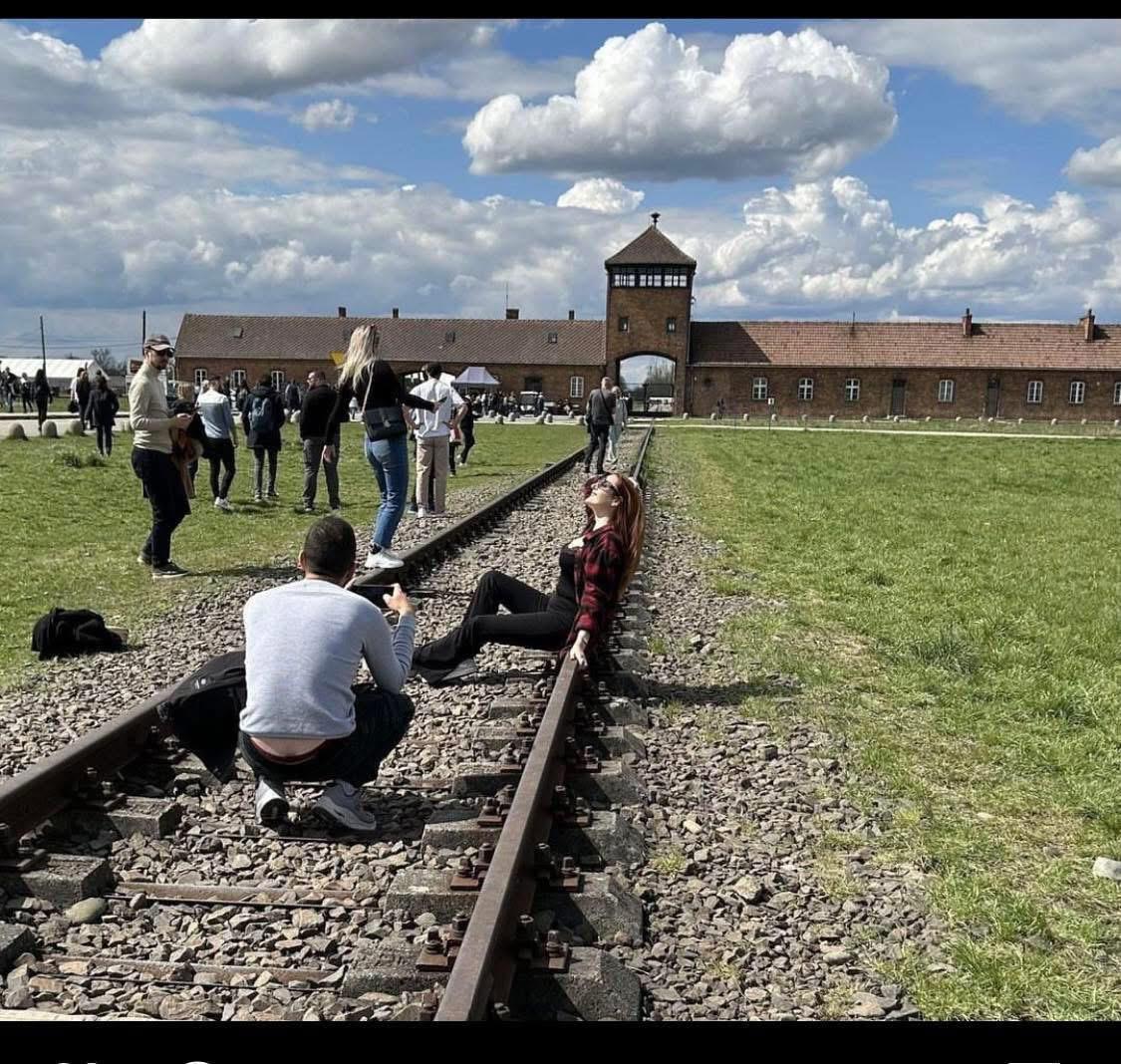 Having a photoshoot in front of Auschwitz.