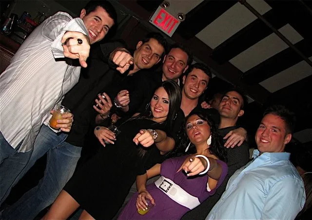 Someone's holding a flip phone, someone's wearing Ed Hardy.