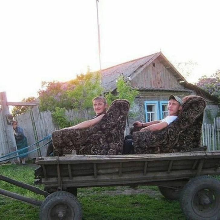 Two Guys on Sofas Being Towed by a Wheelbarrow