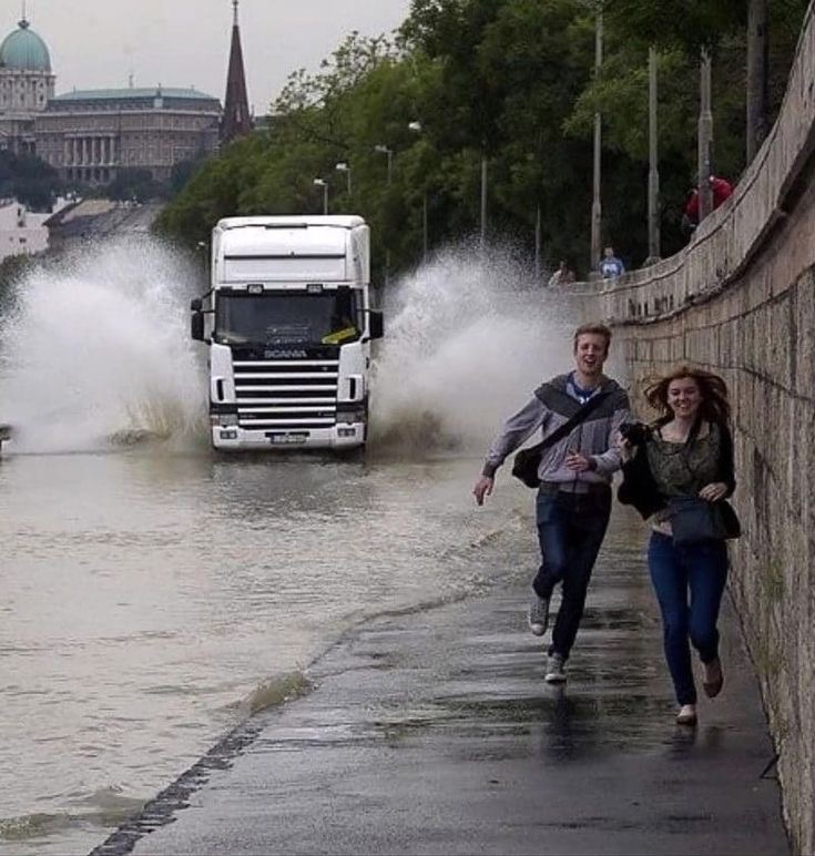 Couple Running from Splashing Truck