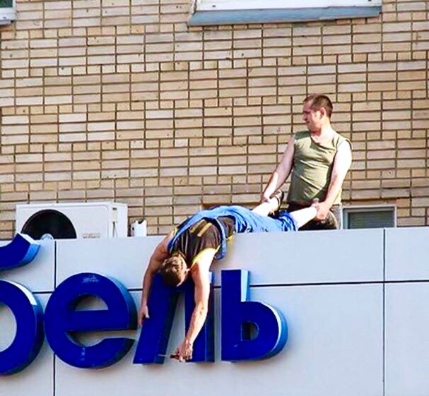 Man Holds Another by Calves