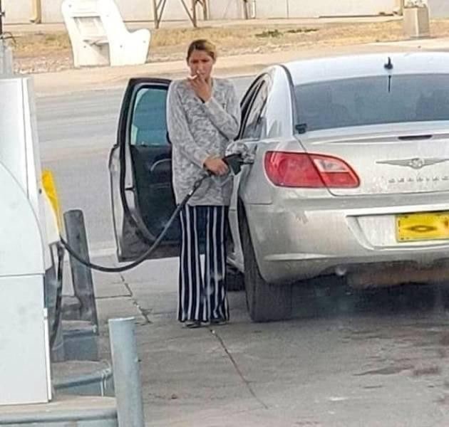 Woman Smoking at Gas Pump