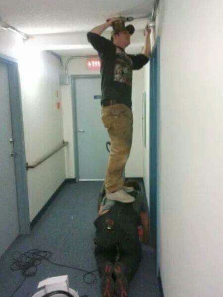 Standing on Friend to Fix Wall