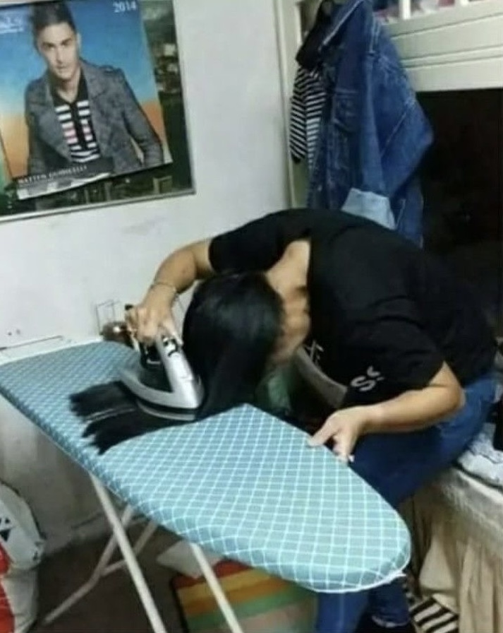 Woman Straightening Hair With an Iron 