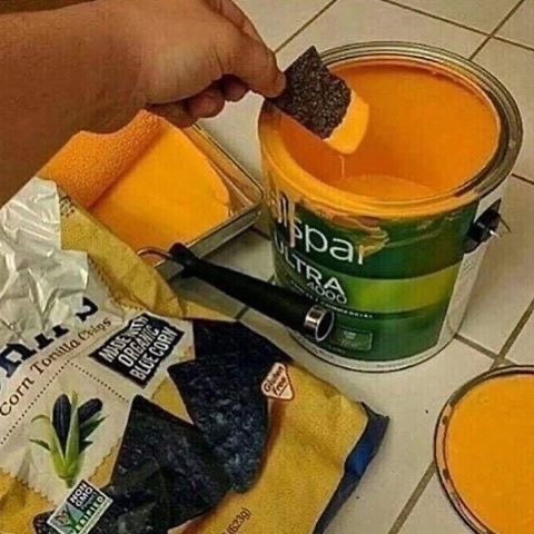 Dipping Chips Into Orange Paint