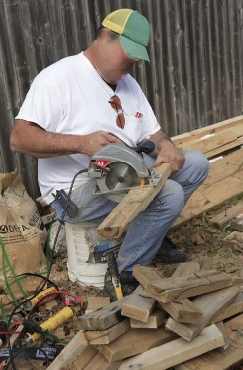 Man Sawing Wood Directly on His Thigh