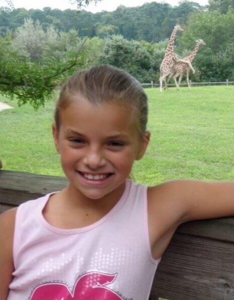 Little Girl Posing with Two Giraffes Doing… 