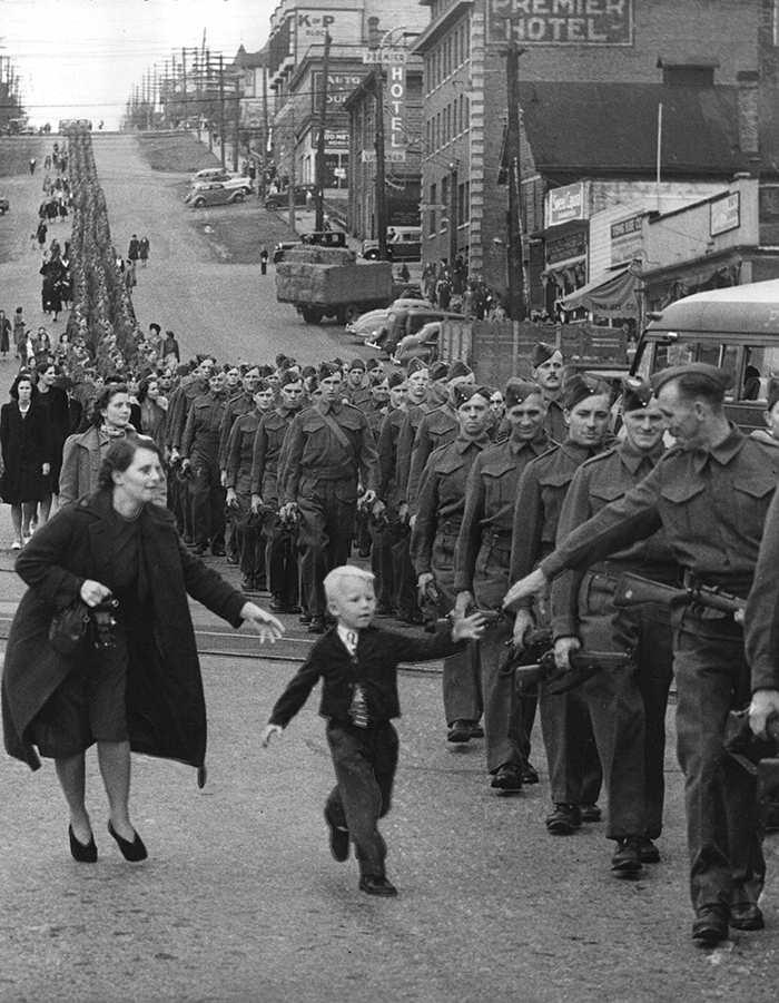 Child reaching for his soldier dad, 1940