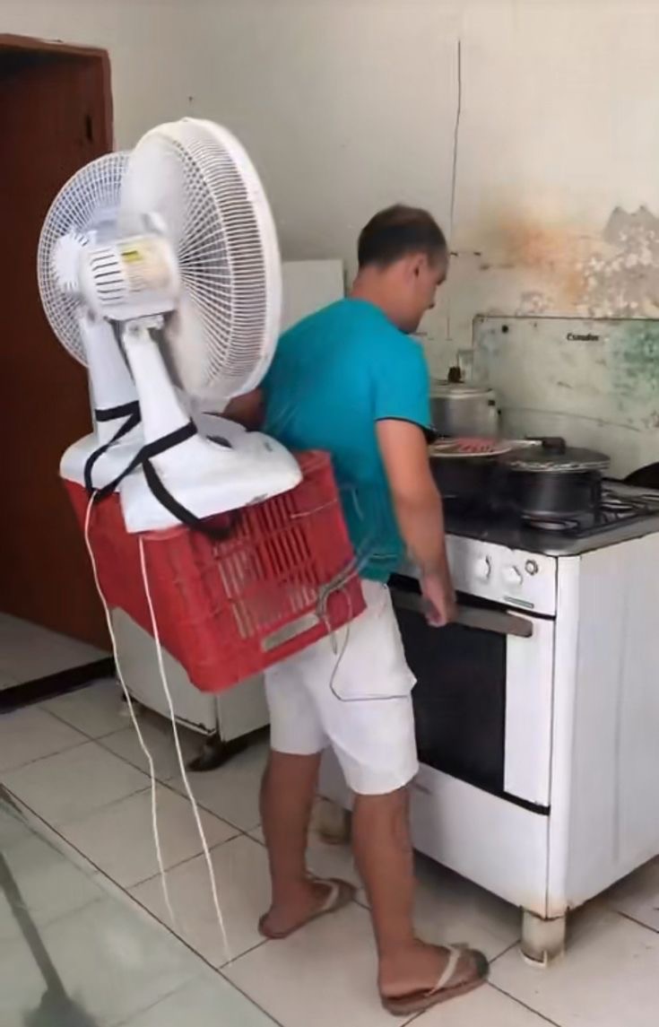 Man Wearing a Box with a Fan Strapped on Top