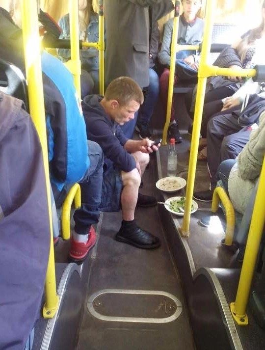 Man Eating With Full Plates on a Bus