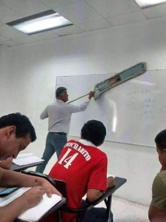 Teacher Cleaning the Chalkboard With a Floor Mop