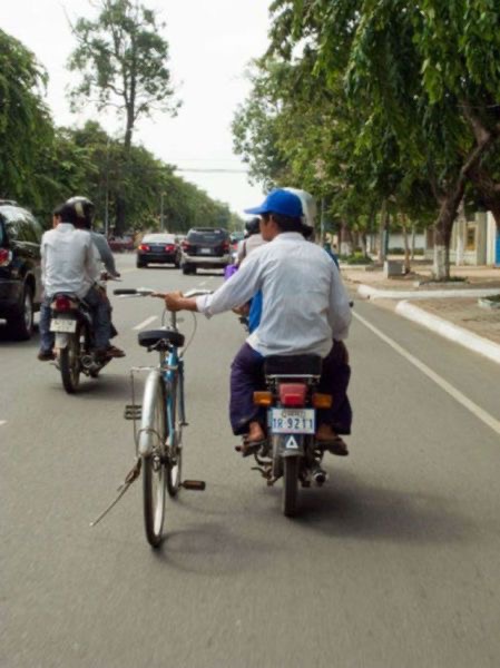 Motorcyclists Dragging a Bicycle Beside Them
