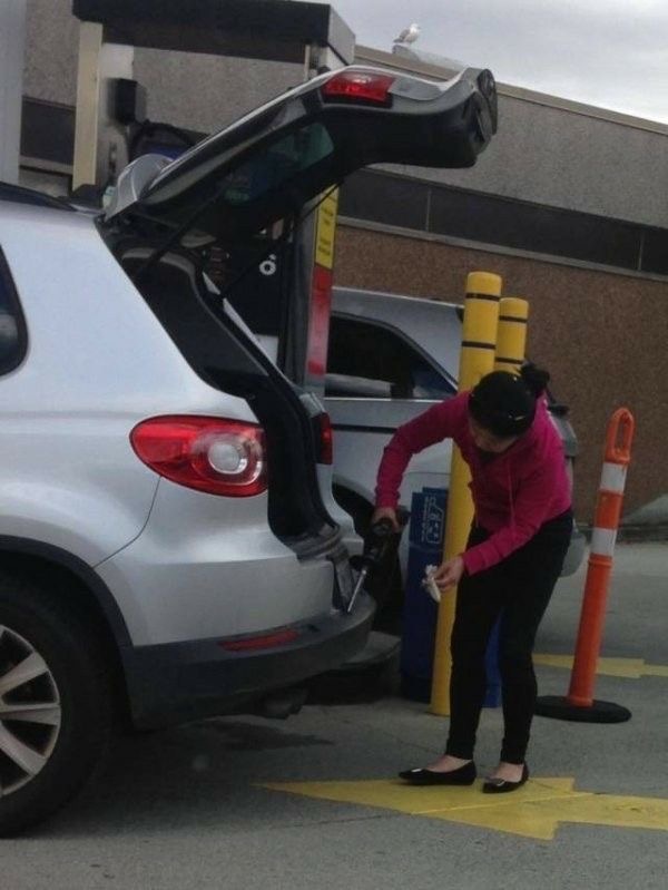 Woman Trying to Pump Gas Into the Trunk of the Car