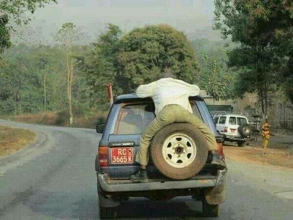 Man Sitting on the Spare Tire on the Back of a Car
