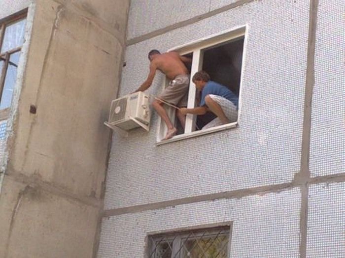 Men Climbing Out a Window to Fix an Air Conditioner